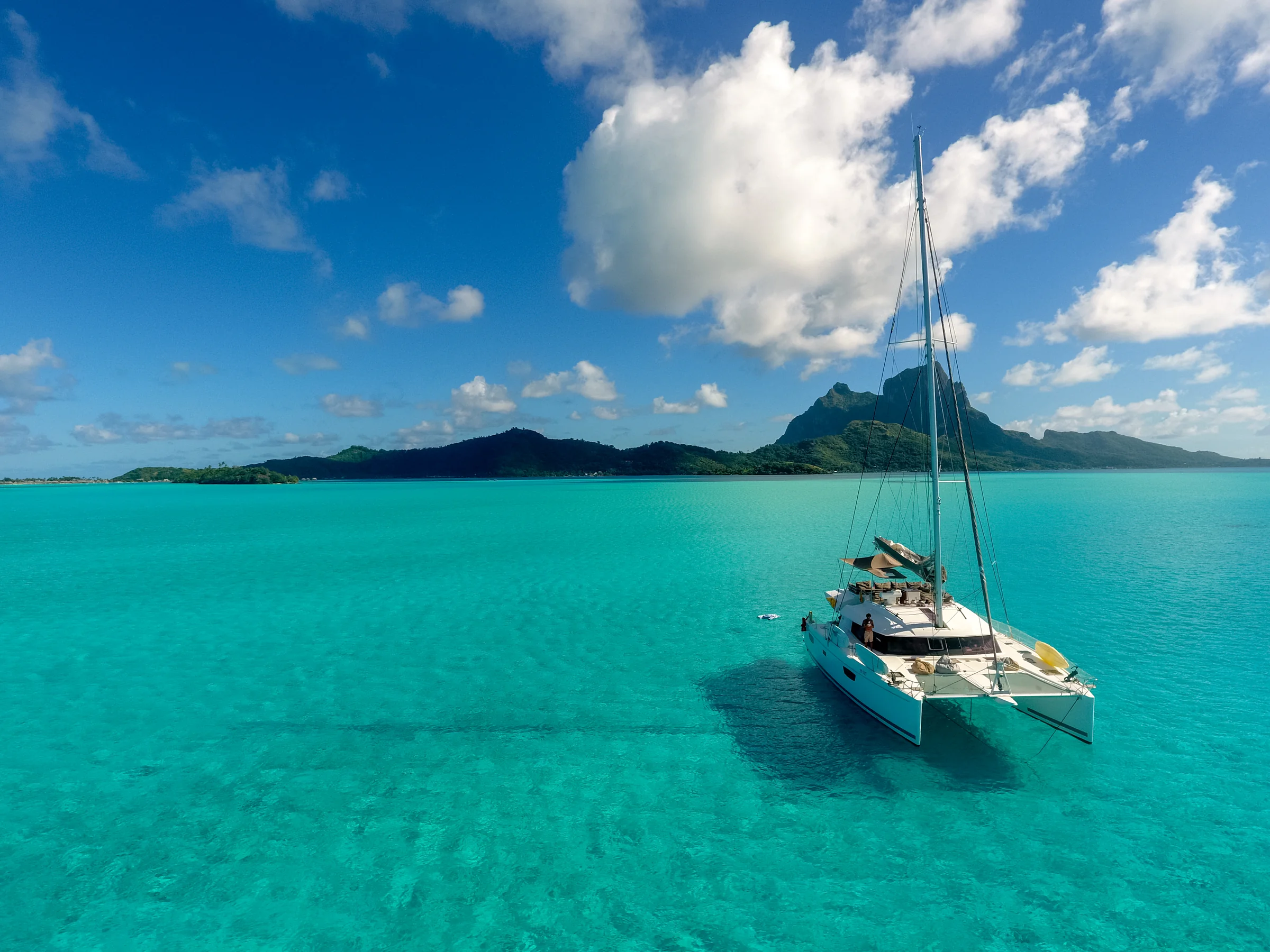 A Sanya 59 catamaran at anchor with Bora Bora in the background.