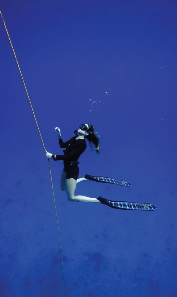 A free-diver suspended in the deep blue.